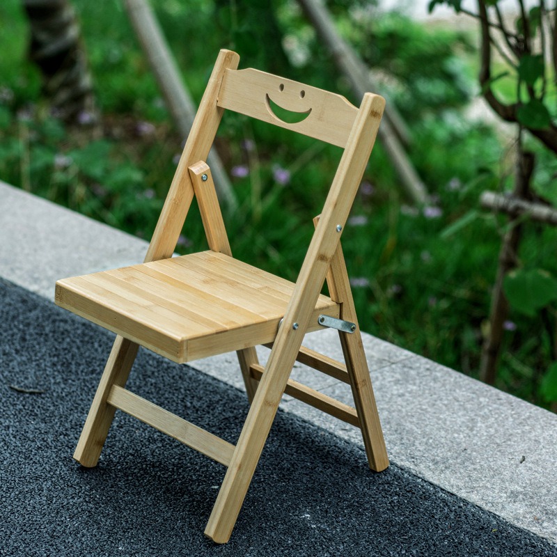 Natural bamboo folding stool with hollow backrest — a lightweight eco option for indoor and outdoor dining.