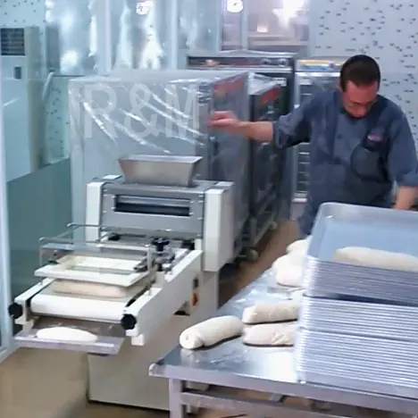 R&M toast moulder bakery operation — operator managing shaped dough on work table